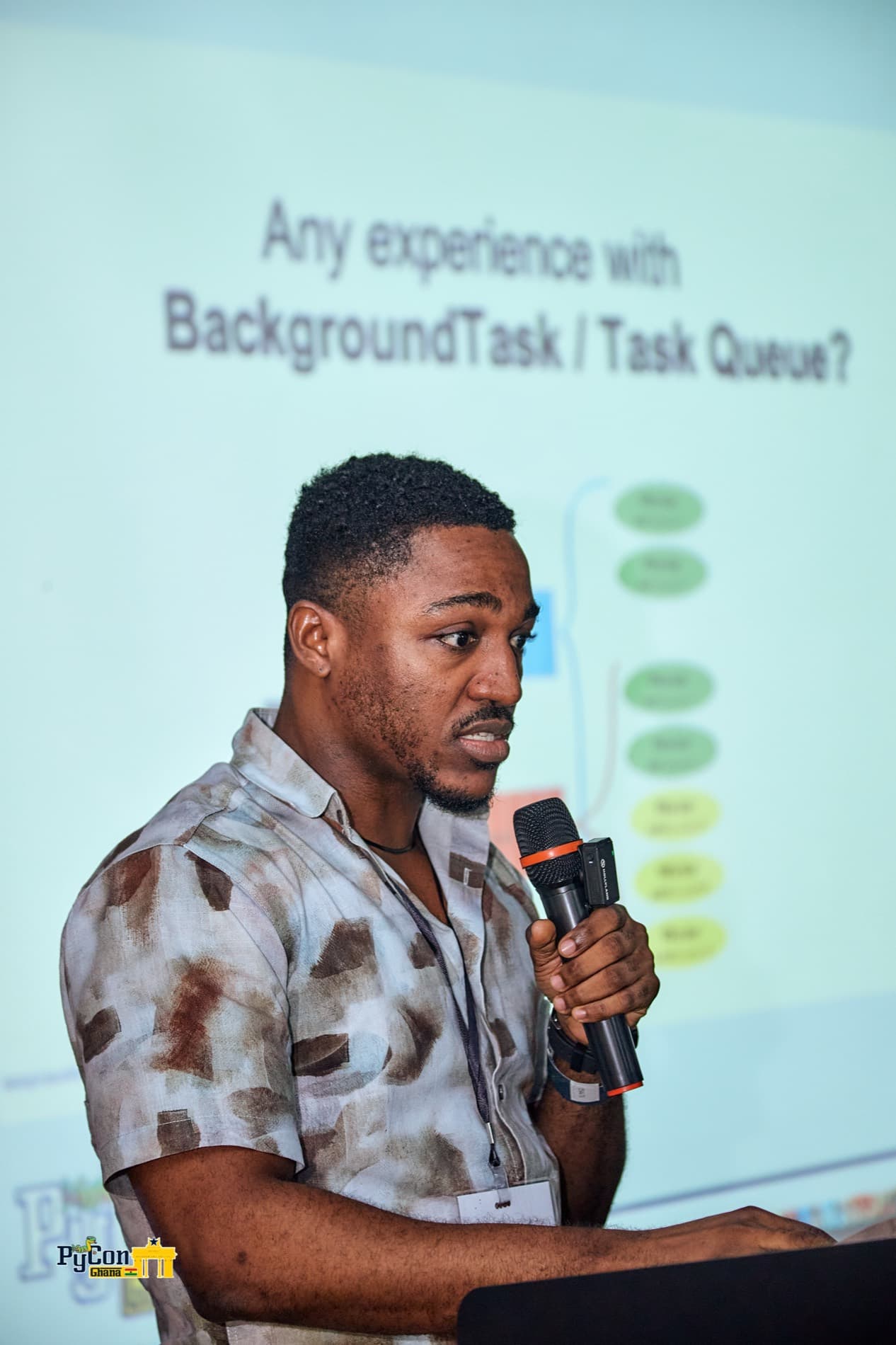 Richard Quaicoe on stage at PyCon Ghana 2026, taking a show of hands on background task experience